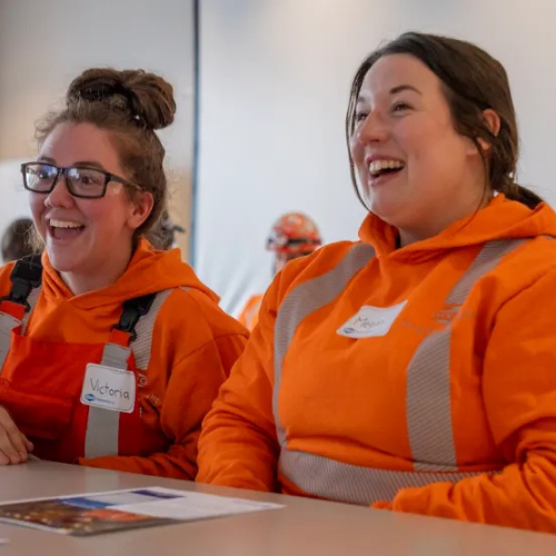 two women in orange laughing